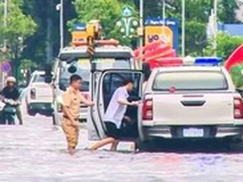 Cảnh sát giao thông lội nước ngập đón thí sinh đi thi lớp 10